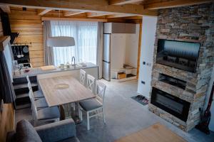 eine Küche und ein Wohnzimmer mit einem Tisch und einem Kamin in der Unterkunft ALPEART HOLIDAY units in Bohinj