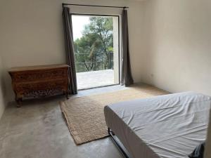 - une chambre avec un lit et une fenêtre ouverte dans l'établissement Villa Bel Air, à Saint-Côme