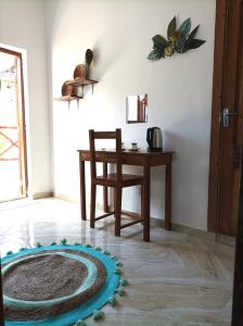 a room with a table and a chair and a rug at Zanzicrown in Nungwi