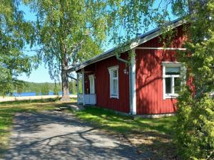 una casa roja con un árbol delante en Perinnetupa Viitikko, 
