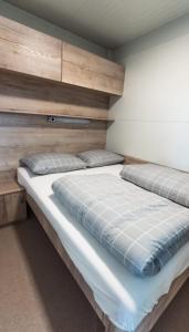 - une chambre avec un lit et une tête de lit en bois dans l'établissement Micro-Cabin by the Kolpa River Metlika, à Gradac