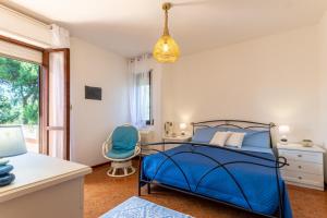 a bedroom with a blue bed and a chair at The Po-Lo Villa indipendente al mare in Su Forti