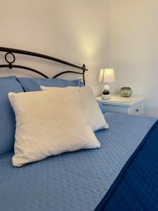 a bed with a white pillow and a table with a lamp at The Po-Lo Villa indipendente al mare in Su Forti