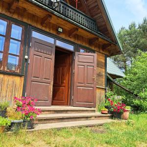una casa con una porta in legno e alcuni fiori di Dom Glówny 