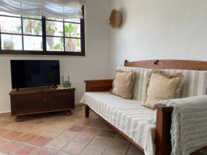 a living room with a couch and a flat screen tv at Casa Lavadeira - VINHAS de NEXE in Faro