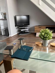 a living room with a glass table and a tv at 114 Bermuda in Hemsby