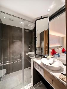 a bathroom with a shower and a sink and a mirror at Aiden by Best Western Hennur in Bangalore