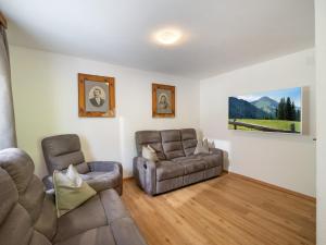 ein Wohnzimmer mit einem Sofa und einem Stuhl in der Unterkunft Apartement Eil in Söll