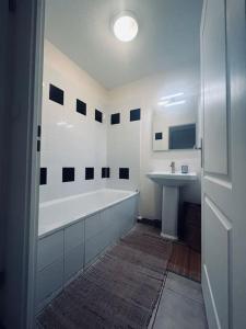 Baño blanco con bañera y lavamanos en # Charme, Calme & Cosy # Brive #, en Brive-la-Gaillarde