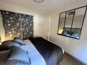 1 dormitorio con cama y espejo en # Charme, Calme & Cosy # Brive #, en Brive-la-Gaillarde
