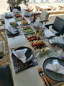 una larga mesa blanca con platos de comida. en Hotel RR en Herceg-Novi