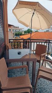 a table and chairs with an umbrella on a balcony at Villa Athina Gia in Sarti