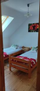 two twin beds in a room with a window at Niedźwiedziówka in Mrągowo
