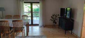 a living room with a table with chairs and a television at Niedźwiedziówka in Mrągowo