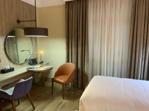Una habitación de hotel con una cama, un escritorio y un espejo. en فندق رؤيا الاندلس النخبة - Roaya Alandalus Elite Hotel, en Medina