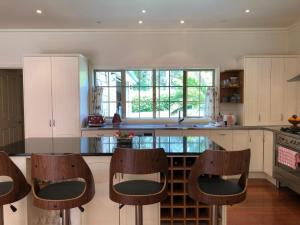 een keuken met houten stoelen en een aanrecht bij N.Z Country Home in Whangarei