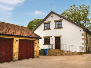 a house with two garage doors and a driveway at Argentum House in Boulmer