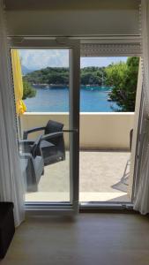 a door to a balcony with a view of the water at Apartment Iva&Andro in Koločep