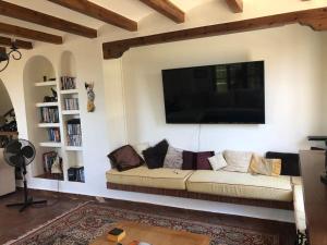 ein Wohnzimmer mit einem Sofa und einem Flachbild-TV in der Unterkunft La fuenta in Málaga