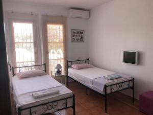 2 Betten in einem Zimmer mit 2 Fenstern in der Unterkunft La fuenta in Málaga