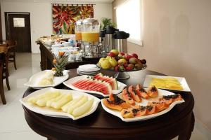 
a table topped with plates of food and drinks at Ipe Center Hotel in Sao Jose do Rio Preto
