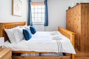 ein Schlafzimmer mit einem großen Bett mit blauen Kissen in der Unterkunft Cozy Apt in Central London in London