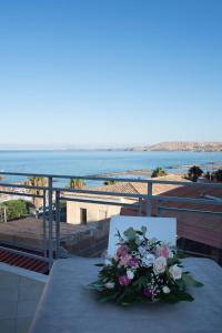 un tavolo con un bouquet di fiori sul balcone di Palazzotto 902 a Crotone