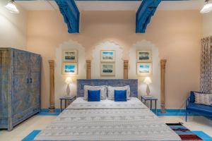 1 dormitorio con 1 cama azul y 2 sillas azules en Stay Vista at Khohar Haveli - 18th Century Palace with Modern Amenities en Gurgaon