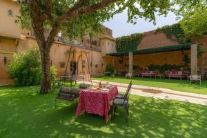 una mesa y sillas en el patio de una casa en Stay Vista at Khohar Haveli - 18th Century Palace with Modern Amenities, en Gurgaon