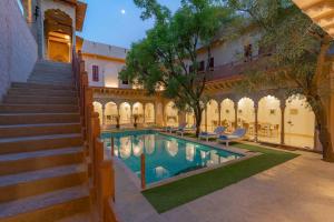 une cour avec une piscine et des escaliers à côté d'un bâtiment dans l'établissement Stay Vista at Khohar Haveli - 18th Century Palace with Modern Amenities, à Gurgaon