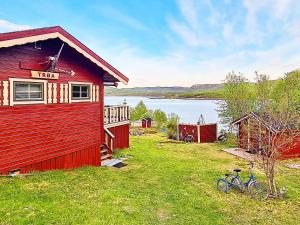 Karpbukt的住宿－7 person holiday home in JARFJORD，一辆红色的房子,一辆自行车停在草地上