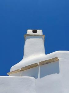 Un phare blanc avec de la neige au-dessus dans l'établissement Sea View Exclusive Studios - Tinos, à Agios Ioannis