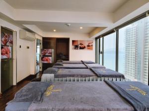 a row of beds in a room with windows at V Hotel Nha Trang in Nha Trang