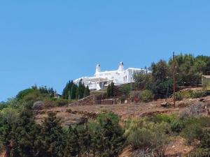 a white house on top of a hill at Sea View Exclusive Studios - Tinos in Agios Ioannis Tinos