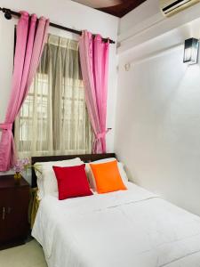 a bedroom with a bed with red and orange pillows at Villa 70C in Dharga Town