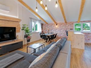a living room with a couch and a tv and a brick wall at Villa Morgan by Rent Istria in Umag