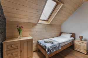 ein kleines Schlafzimmer mit einem Bett und einem Fenster in der Unterkunft Gorczański Resort Domek w Górach Sauna Jacuzzi in Nowy Targ