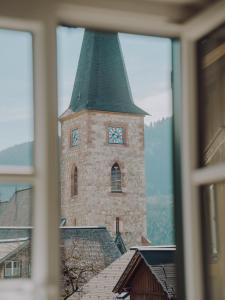 un edificio con una torre con un reloj. en SIEGLGUT, en Altaussee