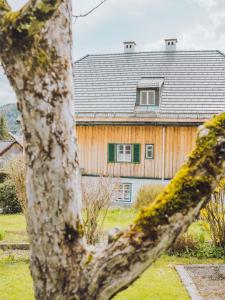 una casa con techo gris y ventanas verdes en SIEGLGUT, en Altaussee