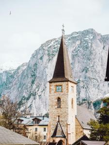 a building with a clock tower in front of a mountain at SIEGLGUT in Altaussee