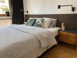sypialnia z białym łóżkiem z drewnianym zagłówkiem w obiekcie M1L Mieszkanie sypialnia +balkon w Warszawie
