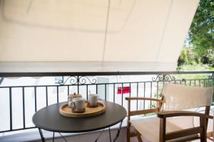 a table with two cups on top of a balcony at Annis House in Skiathos