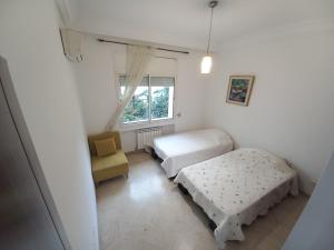 1 dormitorio con 2 camas y ventana en Confort Inn Lac 2, en Túnez