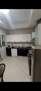 a kitchen with black and white cabinets and a white tile floor at Confort Inn Lac 2 in Tunis