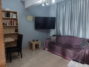 sala de estar con sofá y TV de pantalla plana en Econa Residence, en Poros
