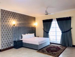 a bedroom with a bed and a large window at Royal Palace Boutique Hotel in Islamabad