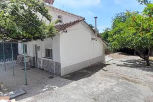 a small white building with a tree in front of it at Μονοκατοικία Καλλικράτεια in Nea Kallikrateia