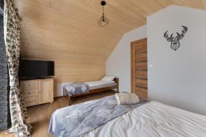 En eller flere senge i et værelse på Gorczański Resort Domek w Górach Sauna Jacuzzi + 23 billeder