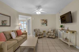 a living room with a couch and a tv at The Palms #601 in Fort Walton Beach