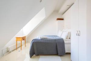 Habitación blanca con cama y escritorio en Stunning Huvilakatu Penthouse, en Helsinki